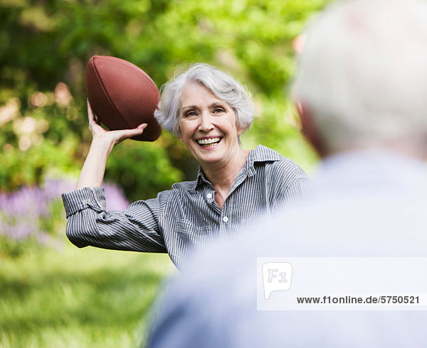 Seniorin wirft Fußball zum Partner