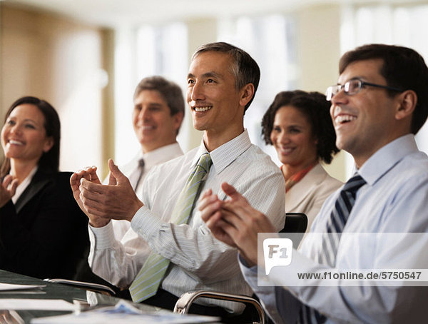 Business colleagues applauding in office