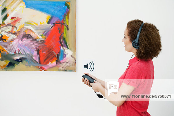 Junge Frau mit Audioguide in der Kunstgalerie