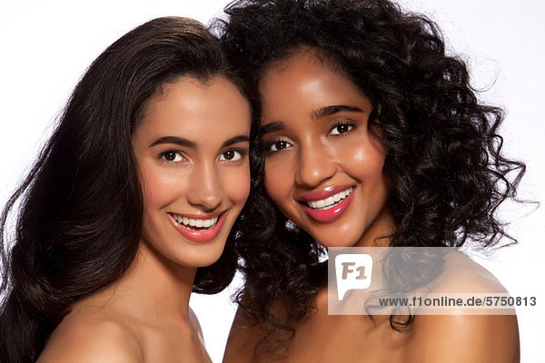 Junge Frauen lächeln vor weißem Hintergrund