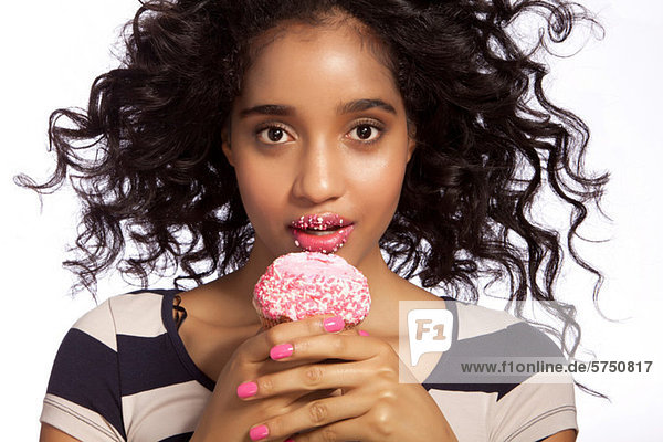 Young woman eating cupcake  studio shot