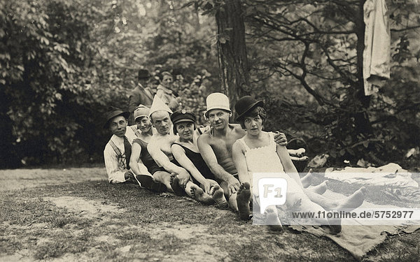 Historical picture of young people sitting on a meadow