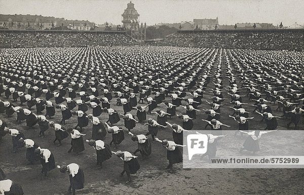 Historical picture of women doing gymnastics in a stadium