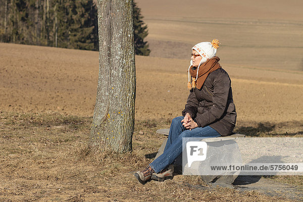 Woman wearing a hat resting on a bench  Limburg an der Lahn  Hesse  Germany  Europe