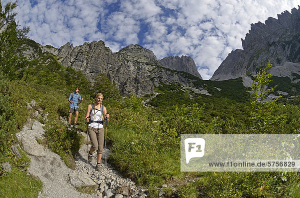 Hikers descending from Gruttenhuette hut  Mt Karlspitze  Ellmauer Tor saddle  Wilder Kaiser massif  Tyrol  Austria  Europe