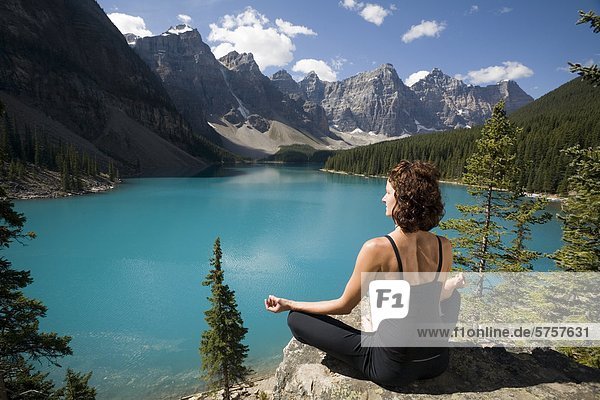 Eine Frau Praticing Meditation  Moraine Lake  Banff Nationalpark  Alberta  Kanada.