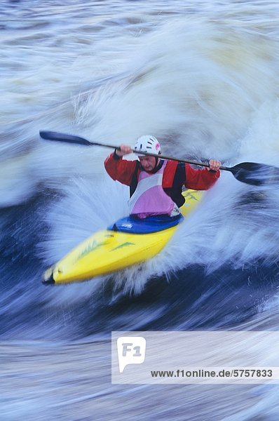 Young man kayaking a standing wave on the ottawa river  Ontario  Canada.