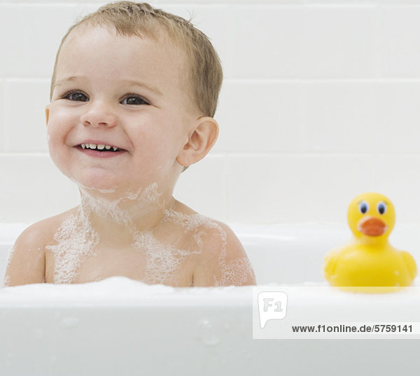 Baby and rubber duck in bath