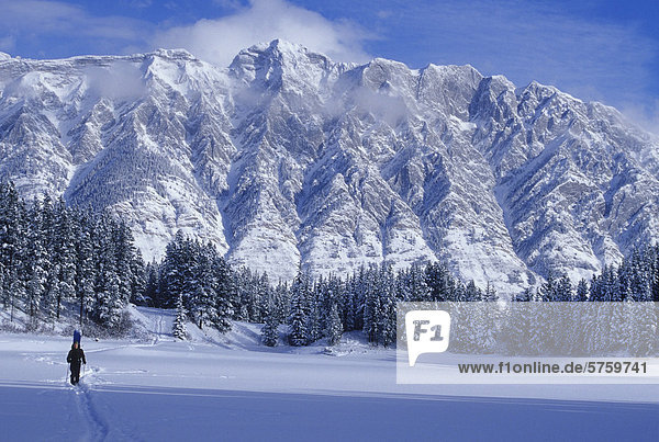 Eine junge Mand Schneeschuhwandern über einen See erreicht man eine epische Hinterland Ski-Destination  Kananaskis Country  Alberta  Kanada