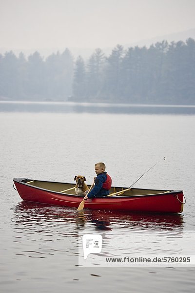 Kleiner Junge geht Angeln mit Hund im Kanu Quelle See  Algonquin Provincial Park  Ontario  Kanada.