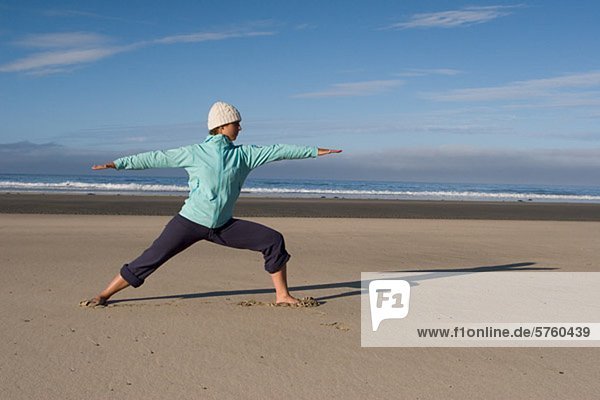 Woman doing yoga by shoreline on beach  Tofino  Vancouver Island  British Columbia  Canada