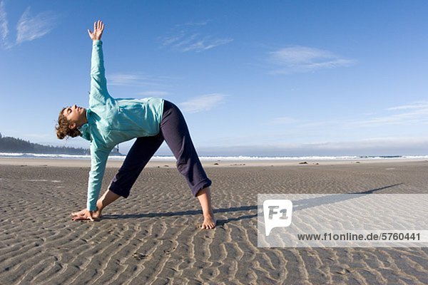 Frau tun Yoga von Küstenlinie am Strand Tofino  Vancouver Island  British Columbia  Kanada