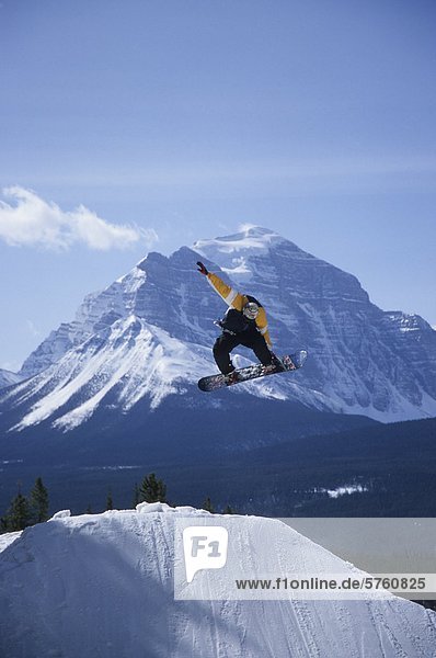 A snowboarder catching some air at Lake Louise resort  Banff National Park  Alberta  Canada