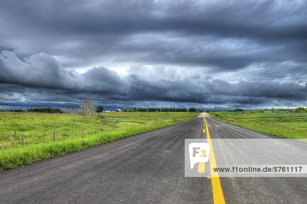 Country highway and storm clouds near Cochrane  Alberta  Canada