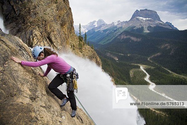 A female rock climber ascends the Takakkaw Falls route (5.6) in Yoho National Park  BC