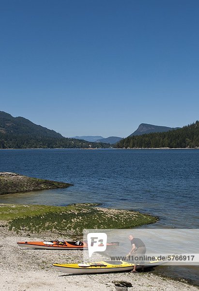 Kayaker on Russell Island with view to Fulford Harbour  Saltspring Island  British Columbia  Canada