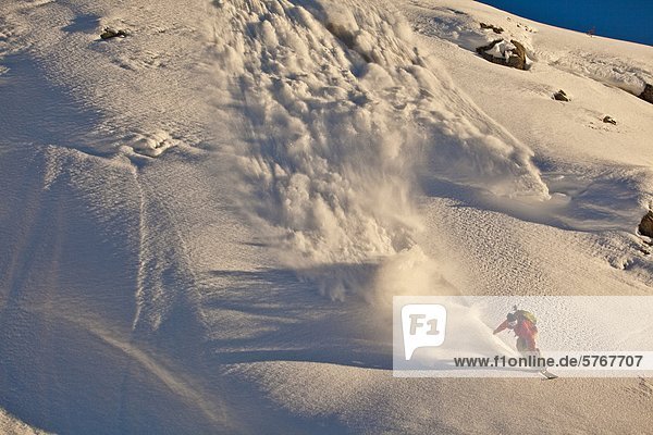 Ein männlicher Snowboarder landet eine Klippe im Powder im Backcountry  Healy Pass  Banff Nationalpark  Alberta  Kanada