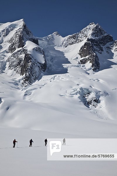 Backcountry skiers ski touring in the Selkirk Range near the Fairy Meadows Backcountry hut  British Columbia  Canada.