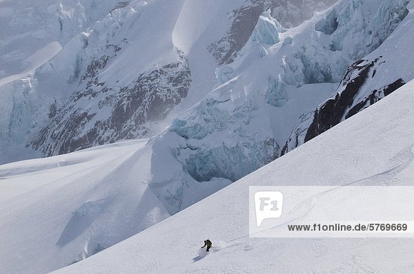 Young man skiing fresh powder in the Selkirk Range near the Fairy Meadows backcountry hut  British Columbia  Canada.