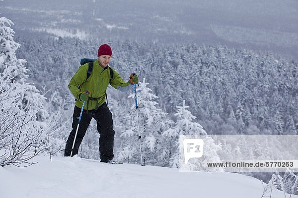 A young man snowshoeing in fresh powder in the eastern townships on Mt. Ham  Quebec  Canada