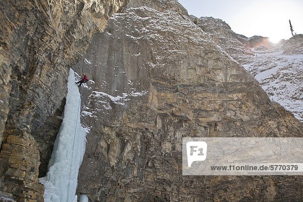 A man rappelling after free soloing the Fang & Fist WI5 Ghost River Valley Alberta Canada