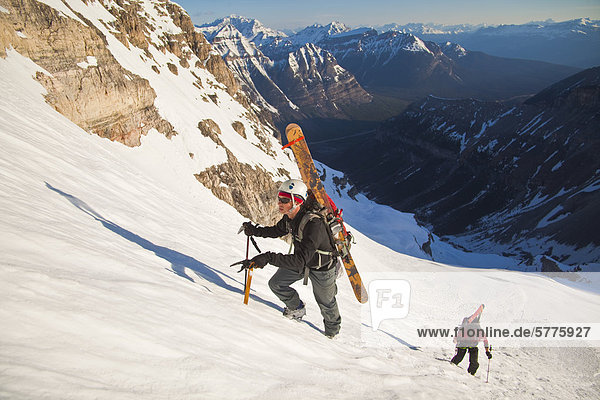 Zwei männliche Hinterland Skifahrer Bootpack bis eine steile Gesicht der Nordwand des Mt. Stanley Kootenay Nationalpark British Columbia Kanada