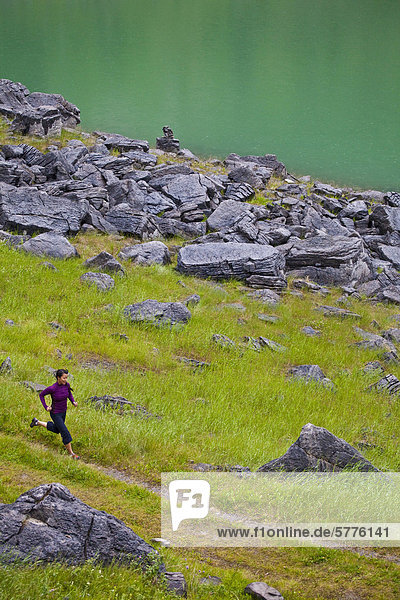 Eine junge asiatische Frau Trail-Läufer entlang des Ufers des Medicine Lake  Jasper Nationalpark  Alberta  Kanada