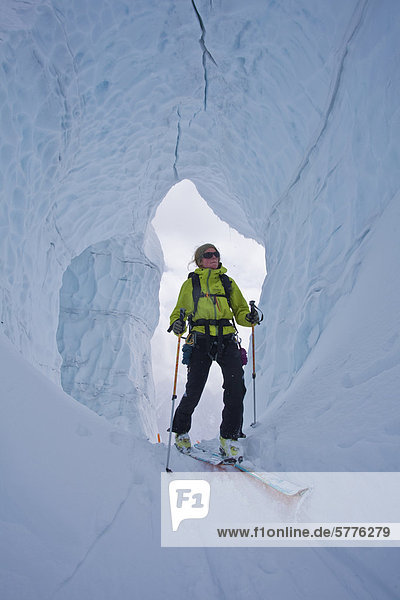 A woman backcountry ski touring through incredible glacier ice. Icefall Lodge  Golden  British Columbia  Canada
