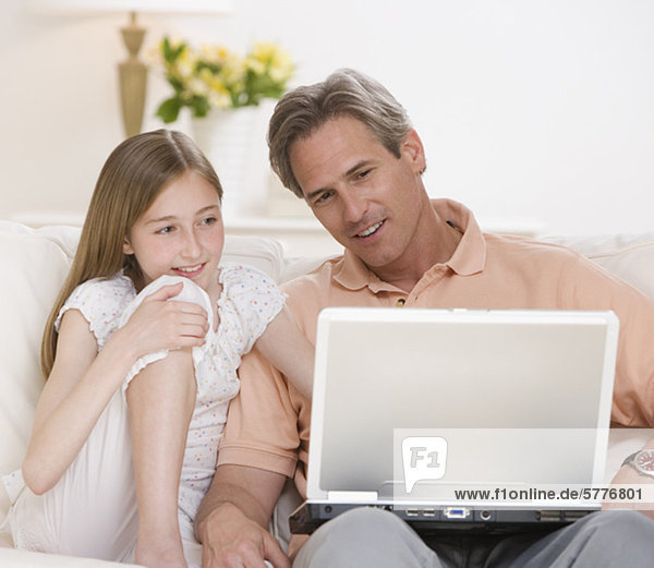 Father and daughter looking at laptop