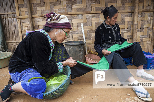 Ältere  traditionell gekleidete Frauen aus dem Bergstamm oder Bergvolk Schwarze Hmong  ethnische Minderheit aus Ostasien  bei der Handarbeit  Stickerei  Nordthailand  Thailand  Asien