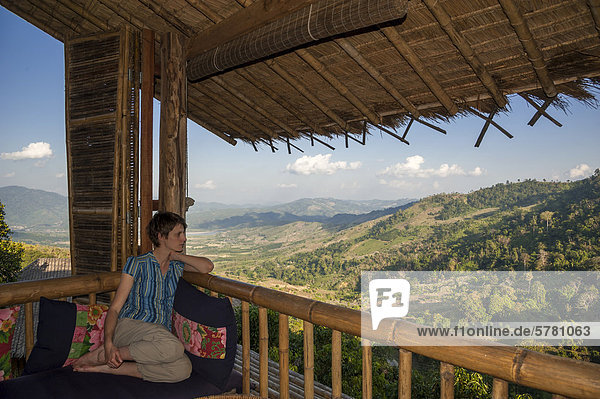 sitzend  Frau  Landschaft  Vordach  Veranda  hinaussehen  Asien  Thailand