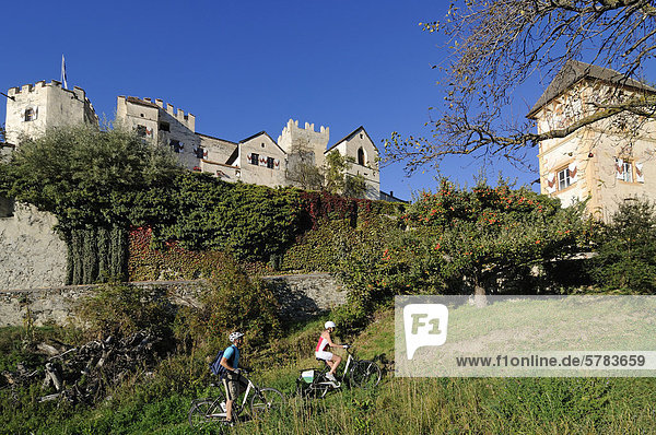 Paar auf Elektrorädern vor Schloss Kastelbell  Tschars  Südtirol  Italien  Europa