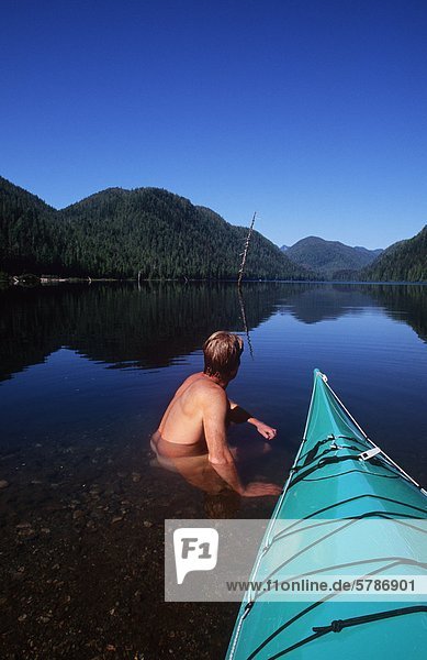 Megin Lake  protected area with kayaker sitting in lake  Clayoquot Sound  Vancouver Island  British Columbia  Canada.