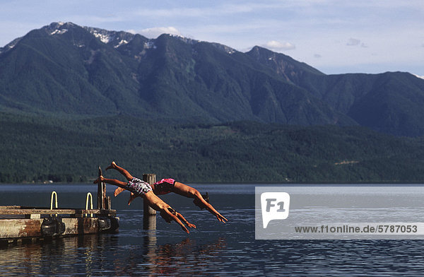 Slocan Lake at New Denver  boys dive off dock  Kootenays  British Columbia  Canada.