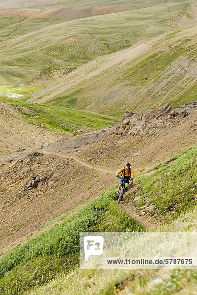 Mountain biker rides the trail down from Deer Pass  Southern Chilcotin Mountains  British Columbia  Canada.