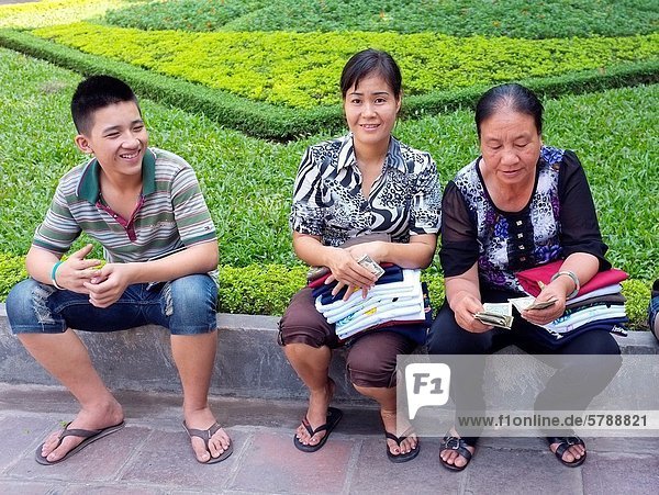 Young man with two women street vendors  Hanoi  Vietnam