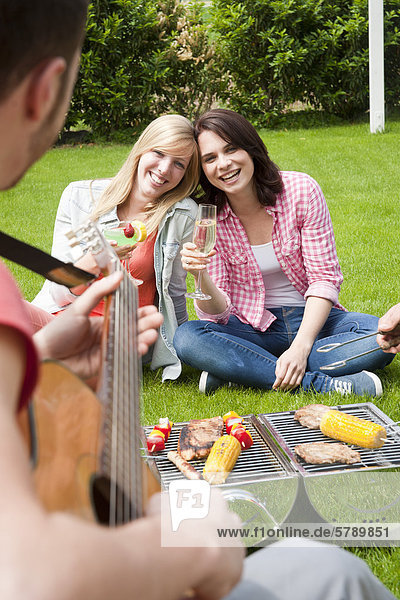 Friends having a barbecue on lawn