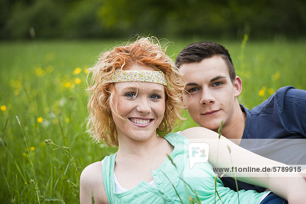 Lächelndes junges Paar liegt auf einer Wiese