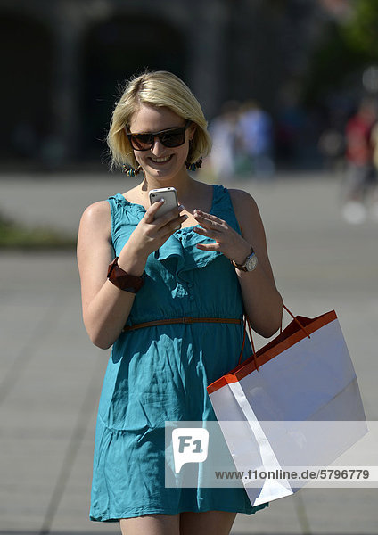 Junge Frau mit Handy beim Shopping Shoppen Einkaufen Königsstra_e Stuttgart Baden-Württemberg Deutschland Europa ÖffentlicherGrund