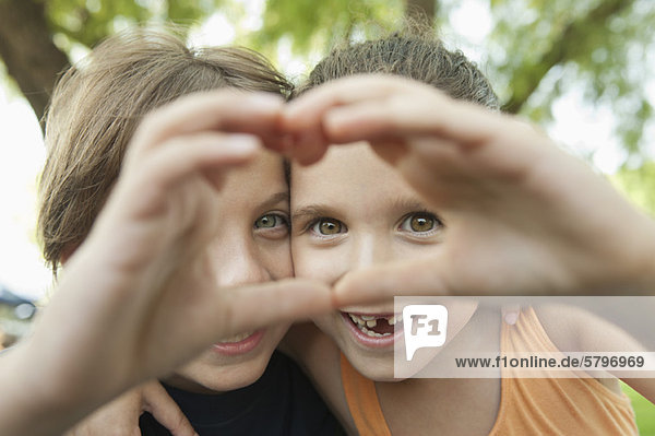 Boy and girl making heart shape with hands