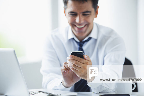 Businessman using smartphone  smiling