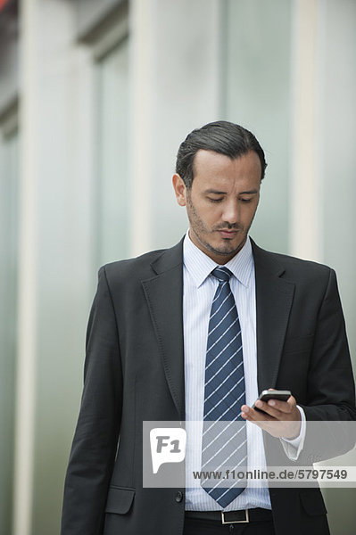 Business Executive Textnachrichten mit Handy