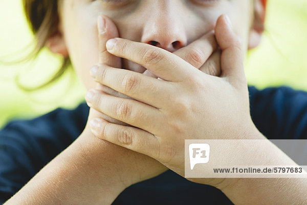 Boy covering mouth with hands  cropped