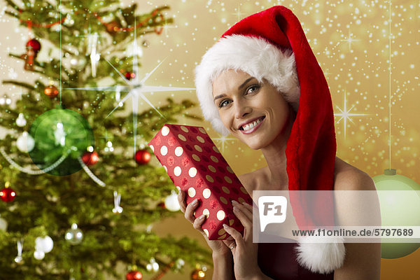 Frau mit Weihnachtsmütze und Weihnachtsgeschenk  Portrait