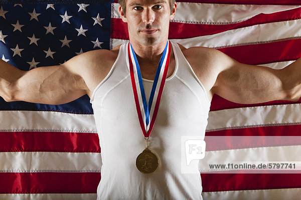 Männlicher Medaillengewinner vor amerikanischer Flagge