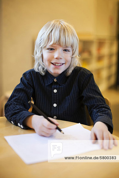 Porträt eines Jungen  der zu Hause Hausaufgaben macht