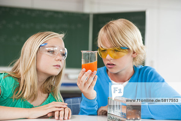Schüler und Schülerin experimentieren im Chemieunterricht