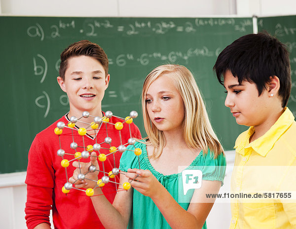 Schüler in der Klasse halten ein Molekular-Modell