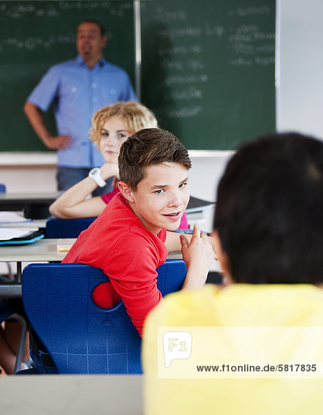 Junge flüstert im Klassenzimmer