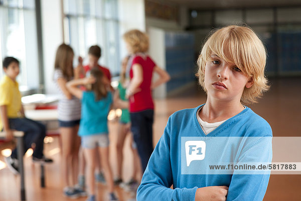 Ernster Junge vor einer Gruppe von Schulkindern